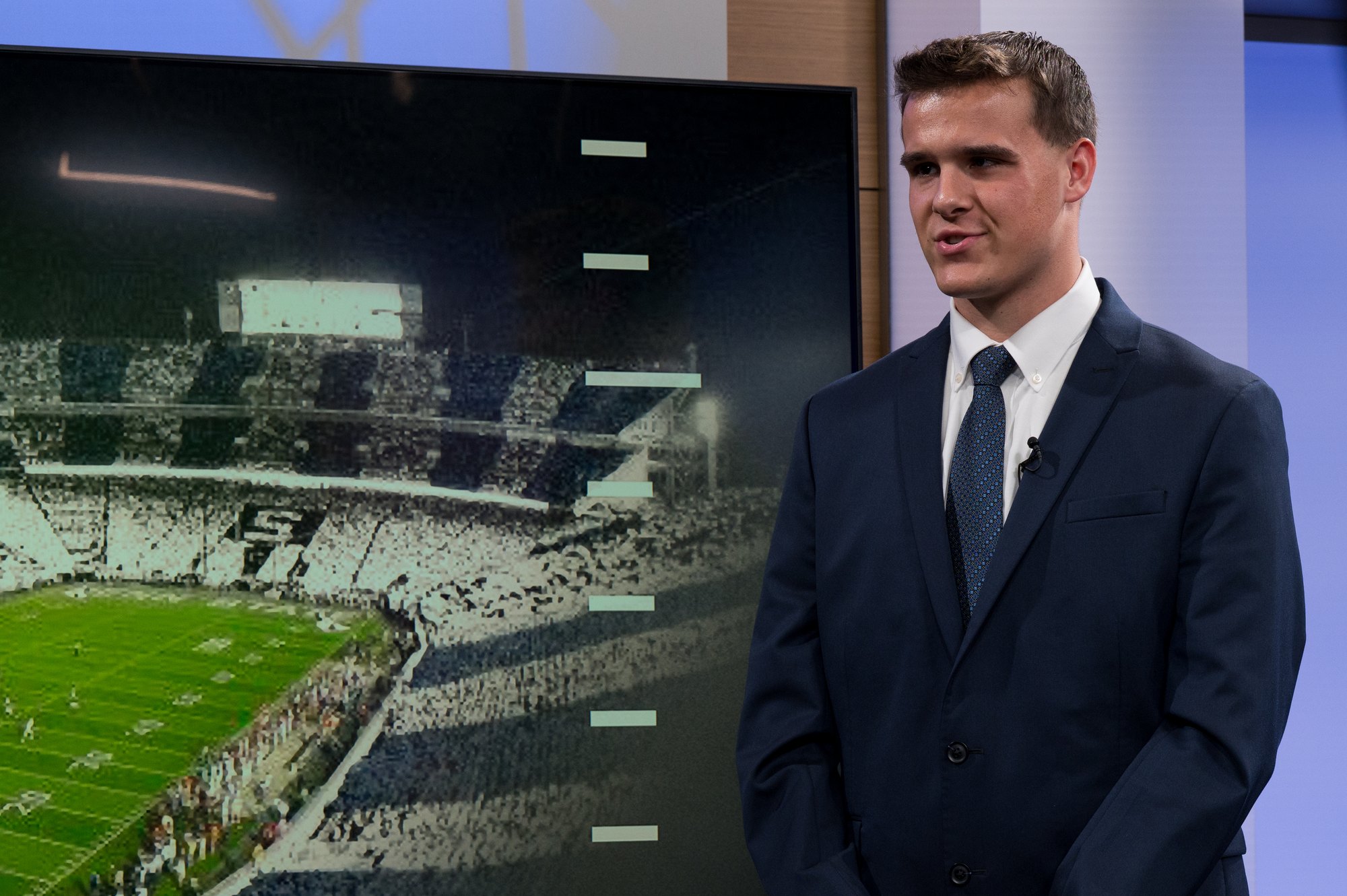 Joseph Draper reports from the studio set with Beaver Stadium on screen at Penn State in State College, Pennsylvania